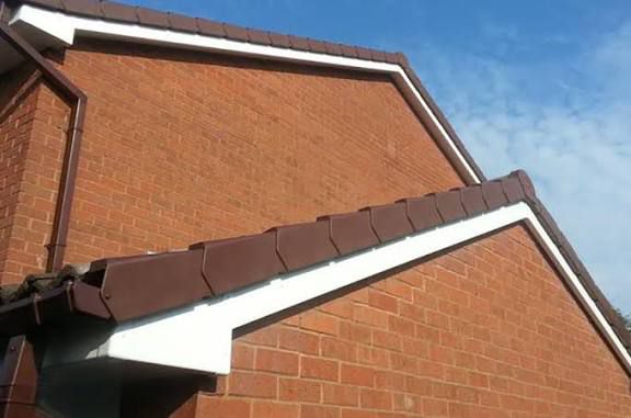Brown fascia boards and dry verge system on detached house